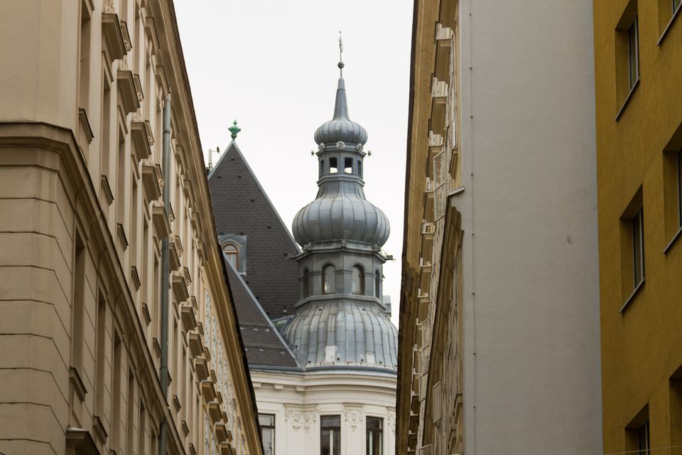 Grey onion-domed spire between two ochre buildings