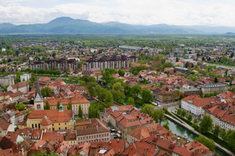 Ljubljana’s red rooftops and the Ljubljanica from the castle, mountains on the horizon