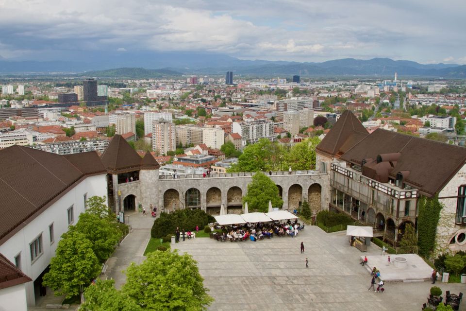Castle courtyard with arcades and the city stretching to the hills