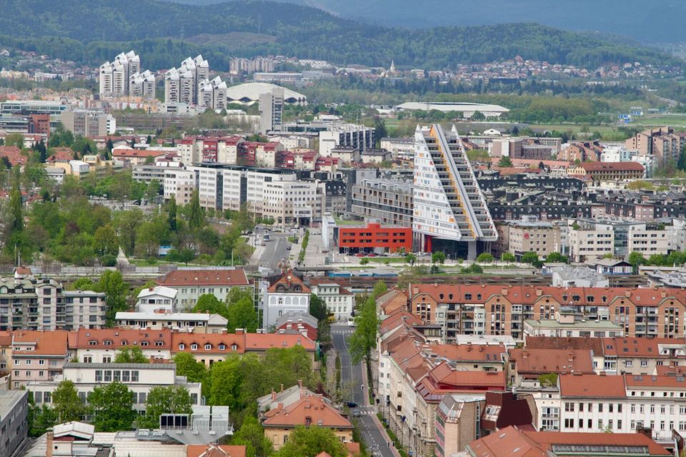 Modern districts and tower blocks beyond the old town, under grey clouds