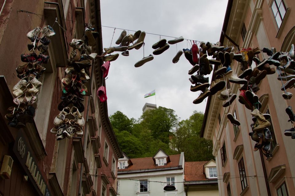 Pairs of shoes hanging from the wires above a street