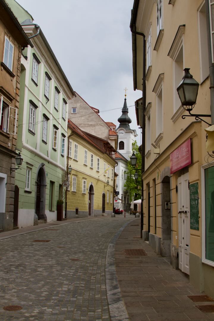 Quiet cobbled lane with a church tower at the end