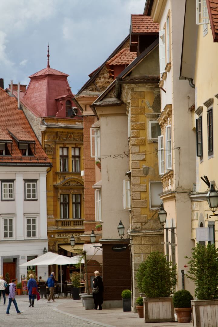Street corner with café tables under tall old houses