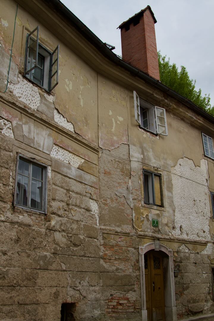 Weathered stone house with small windows and a chimney