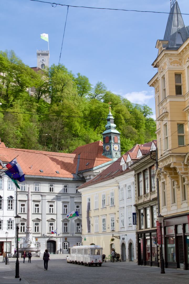 Town Square with the Town Hall tower, the castle above and a tourist train