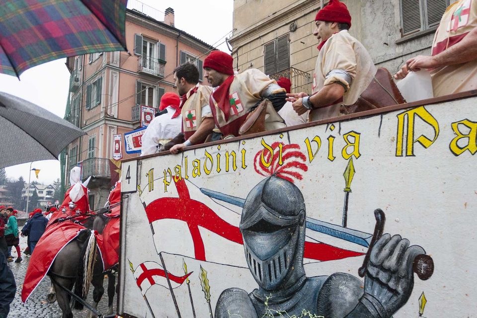 Orange throwers in red caps on a painted cart with a knight