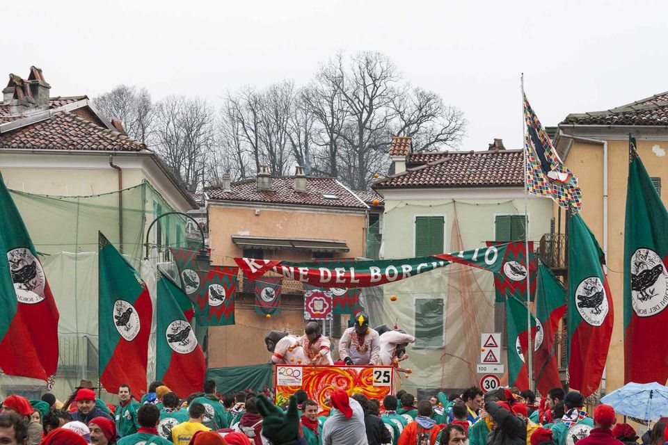 Red and green banners and a net-wrapped cart above a crowd