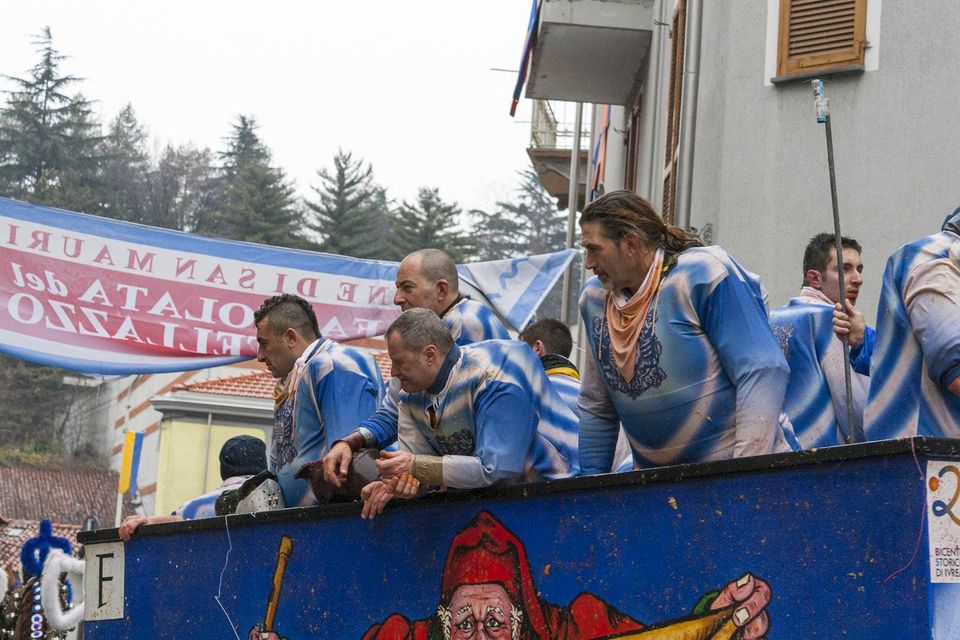 Team in blue and white striped shirts on a rainy cart