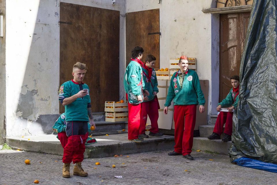 Team members in green and red jackets resting by wooden crates