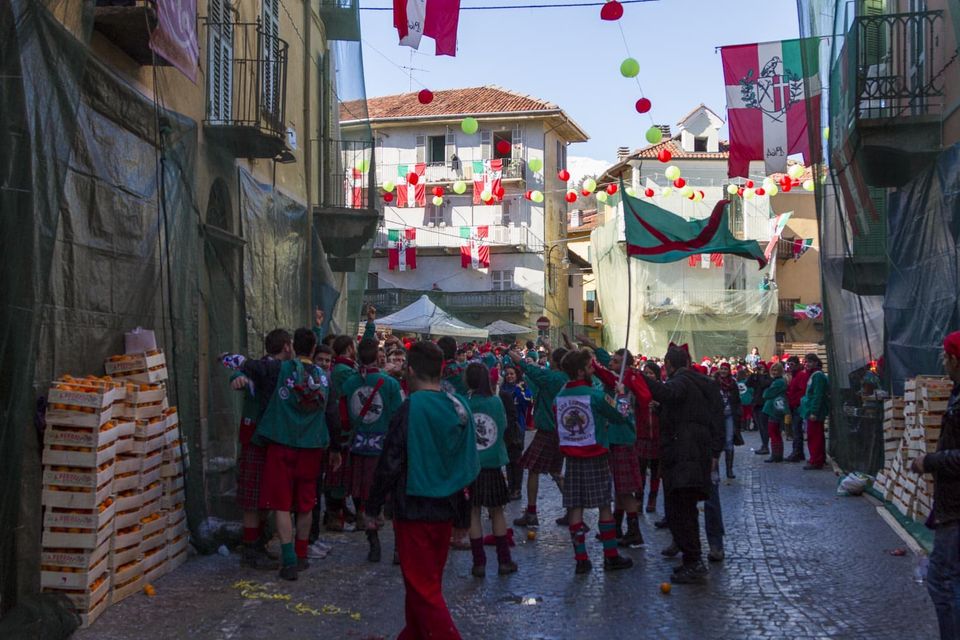 Team in green and red jerseys gathered in a flag-hung street