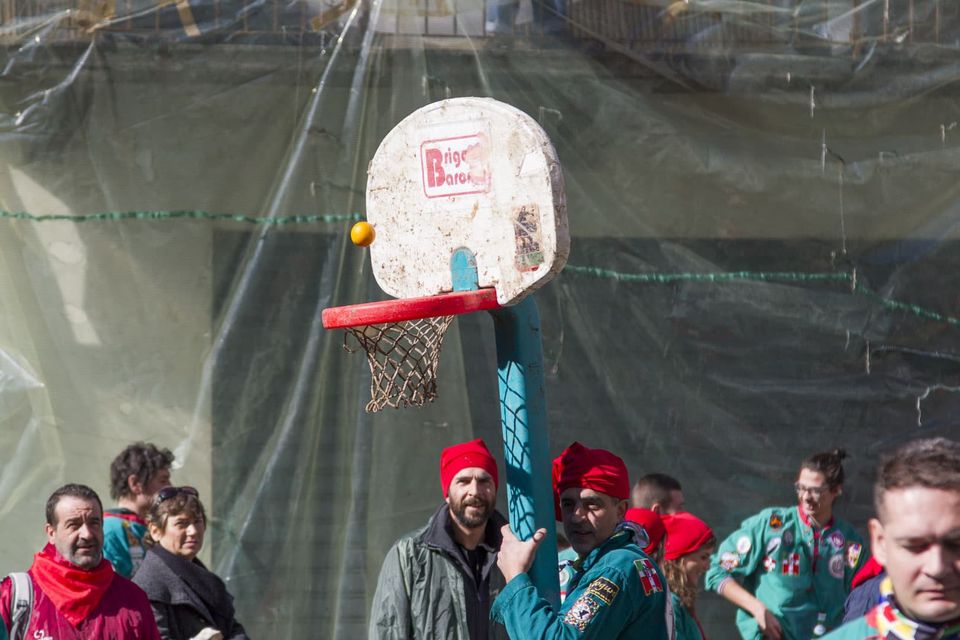 Basketball hoop held up by a man in a red cap