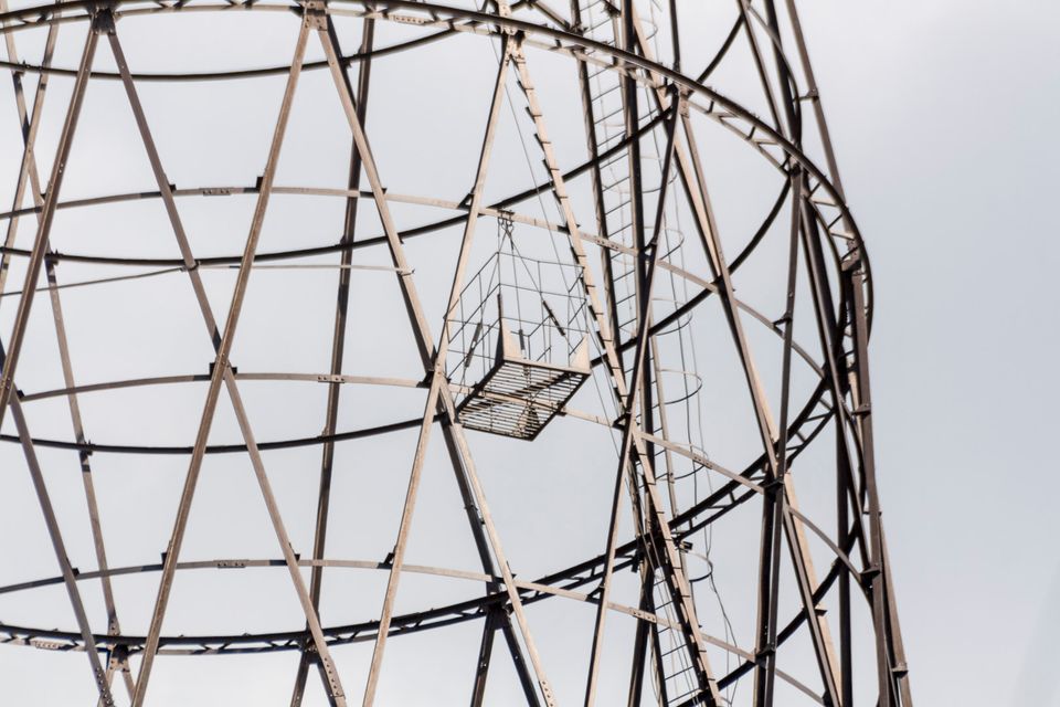 Rusty maintenance cage hanging inside the tower lattice