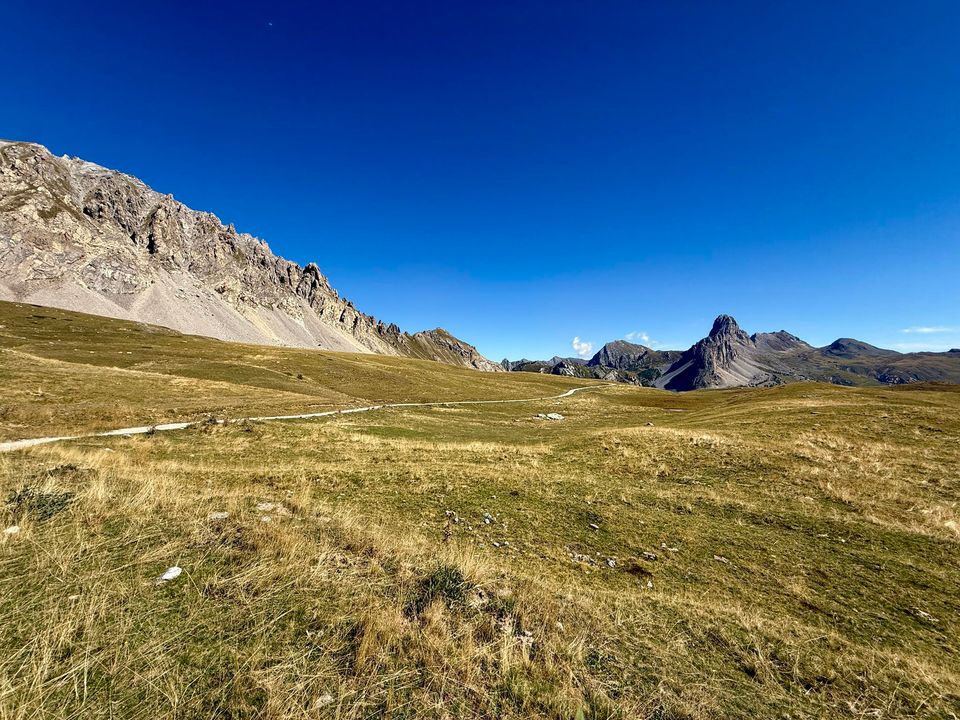 Pale scree ridge above the plateau, a rock tooth in the distance
