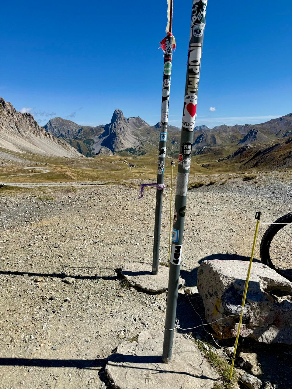 Sticker-covered poles at the Gardetta pass, Rocca la Meja beyond