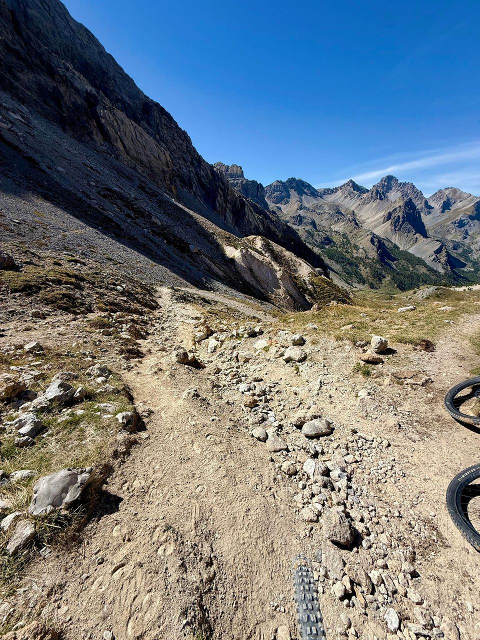 Rocky singletrack dropping steeply between scree slopes